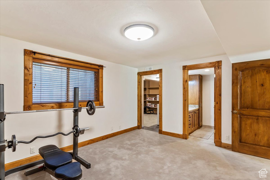Exercise area with baseboards and light carpet