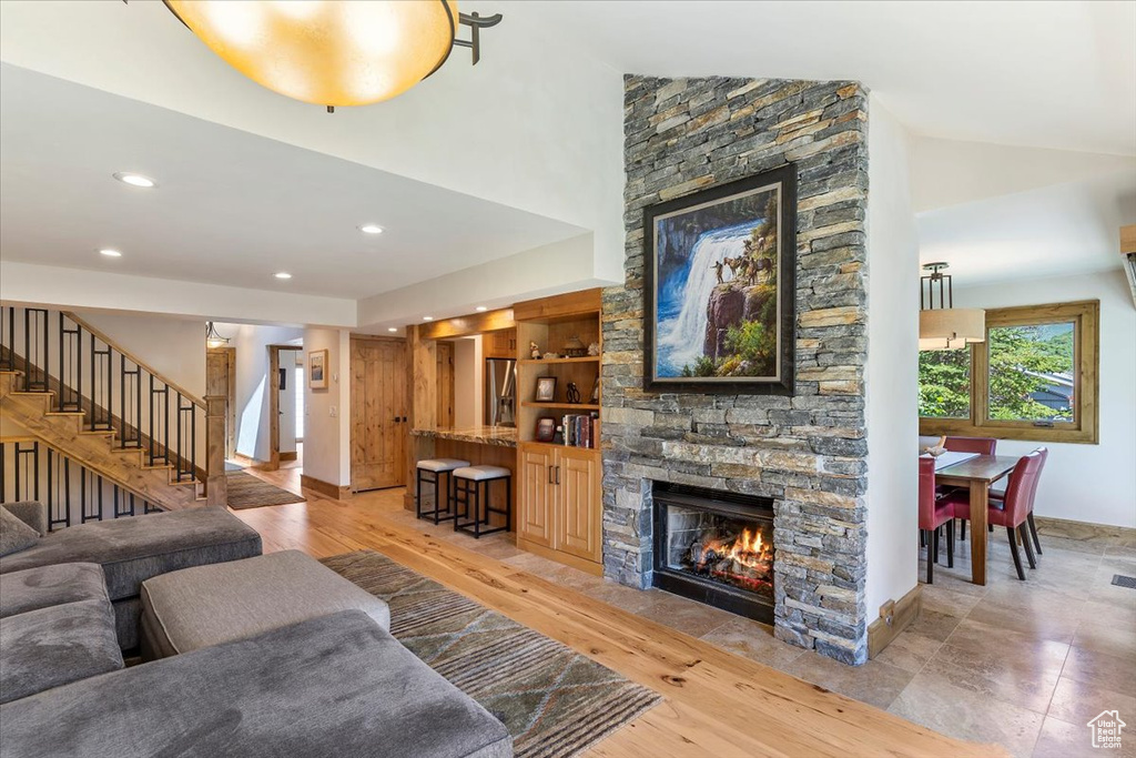 Living room featuring a fireplace, stairs, recessed lighting, baseboards, and high vaulted ceiling