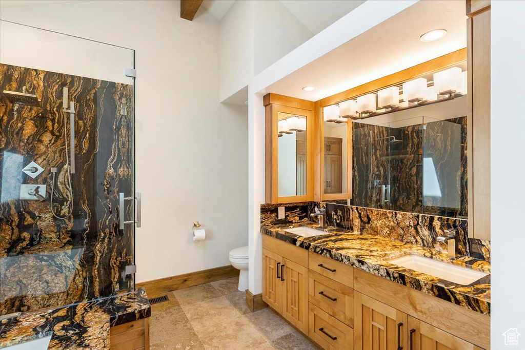 Full bathroom with baseboards, double vanity, toilet, a marble finish shower, and recessed lighting