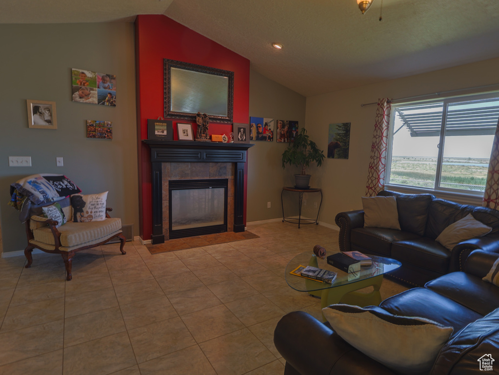 Living area with vaulted ceiling, a fireplace, tile patterned flooring, baseboards, and recessed lighting