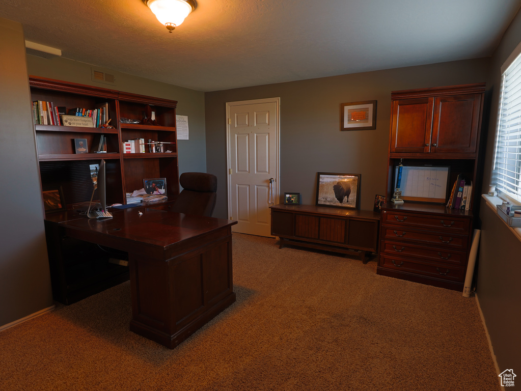 Office space with light colored carpet and baseboards
