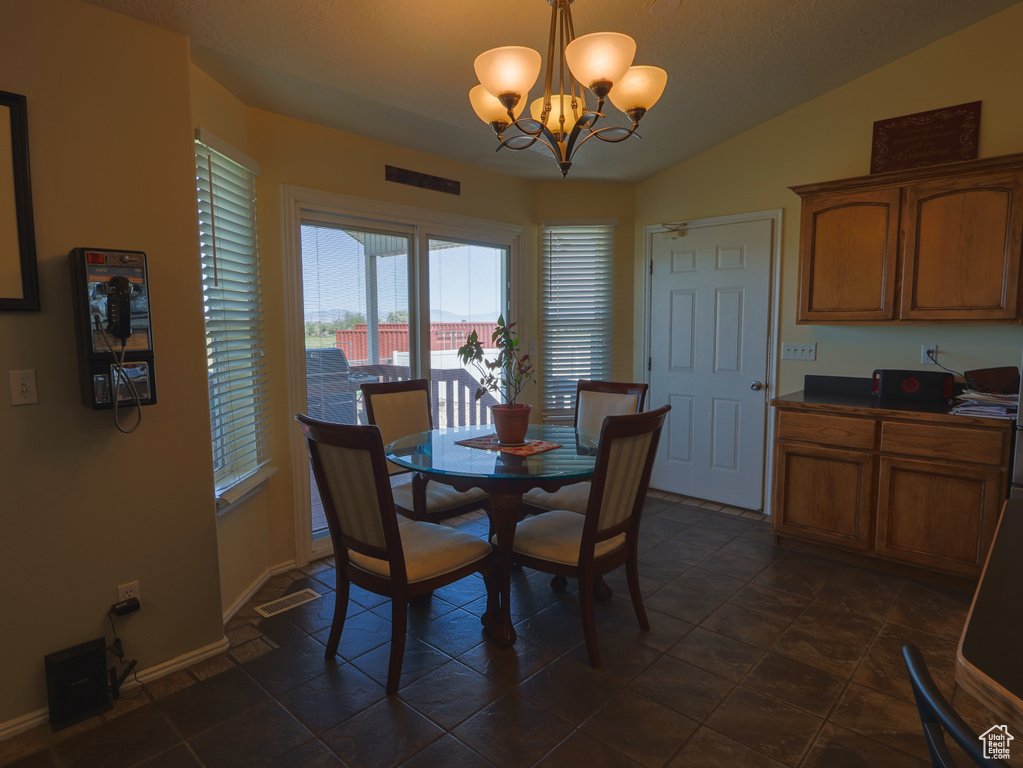 Dining room with a chandelier, baseboards, and vaulted ceiling