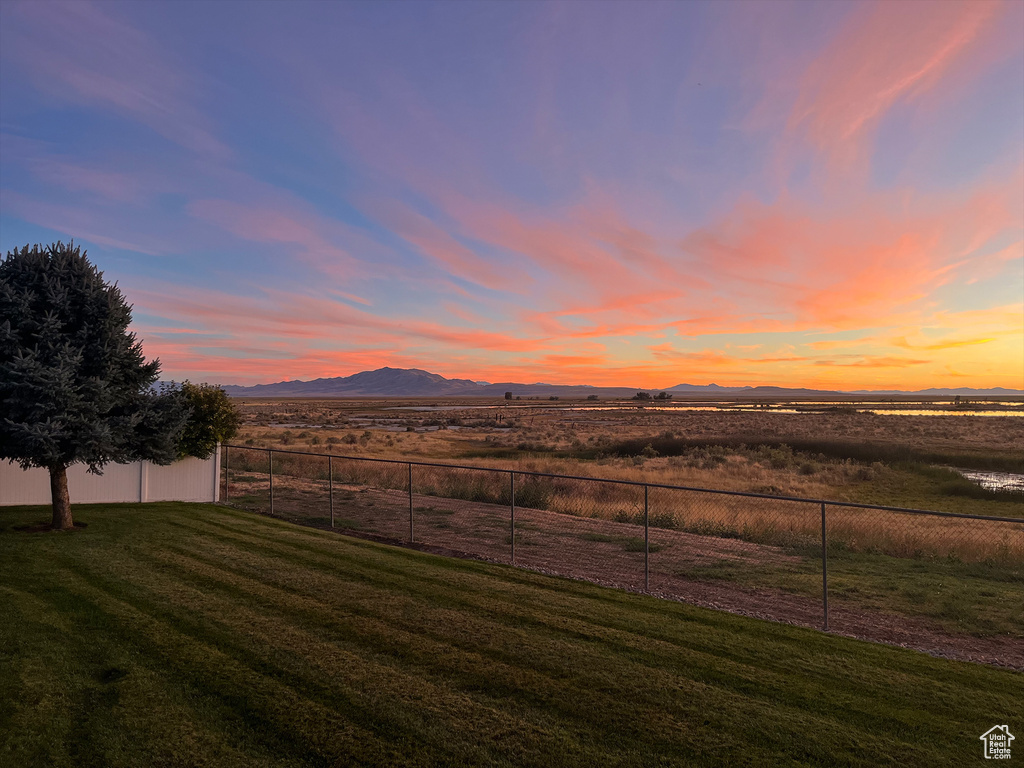 Yard at dusk featuring a mountain view and a view of countryside