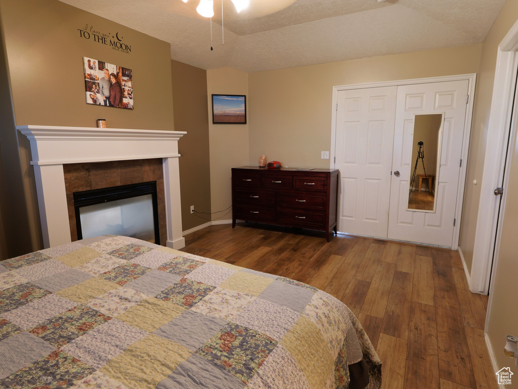Bedroom featuring wood finished floors, baseboards, and a fireplace