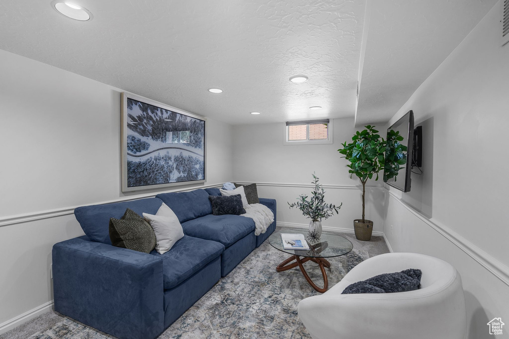 Living area with recessed lighting, a textured ceiling, baseboards, and carpet