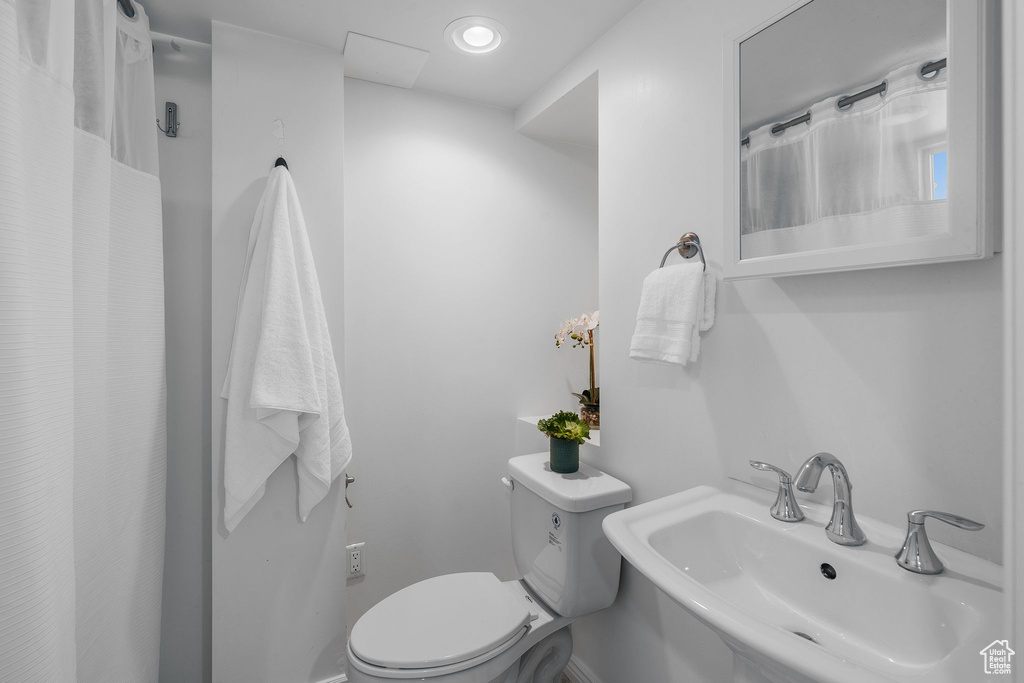 Bathroom with a sink, toilet, and curtained shower