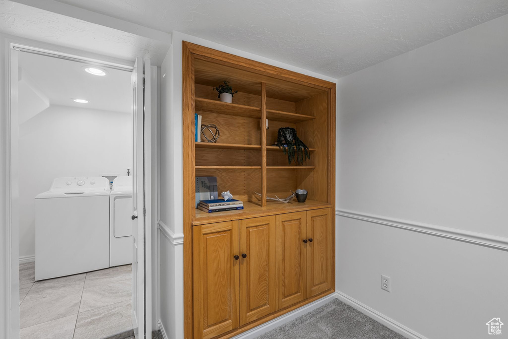Detailed view of washing machine and clothes dryer, recessed lighting, and baseboards