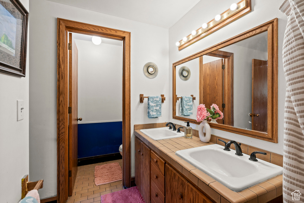 Bathroom featuring double vanity and toilet