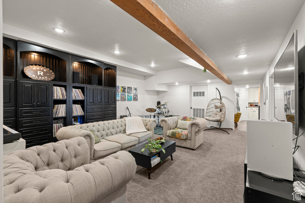 Carpeted living area featuring beamed ceiling, recessed lighting, and a textured ceiling