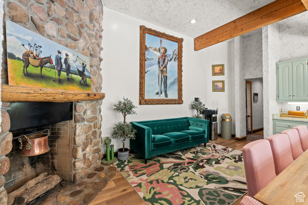 Living room with wood finished floors and a stone fireplace