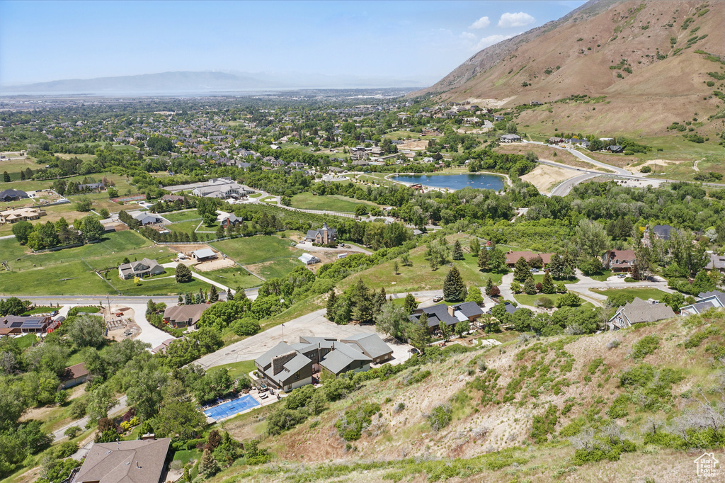 Aerial view of property and surrounding area featuring a water and mountain view and nearby suburban area