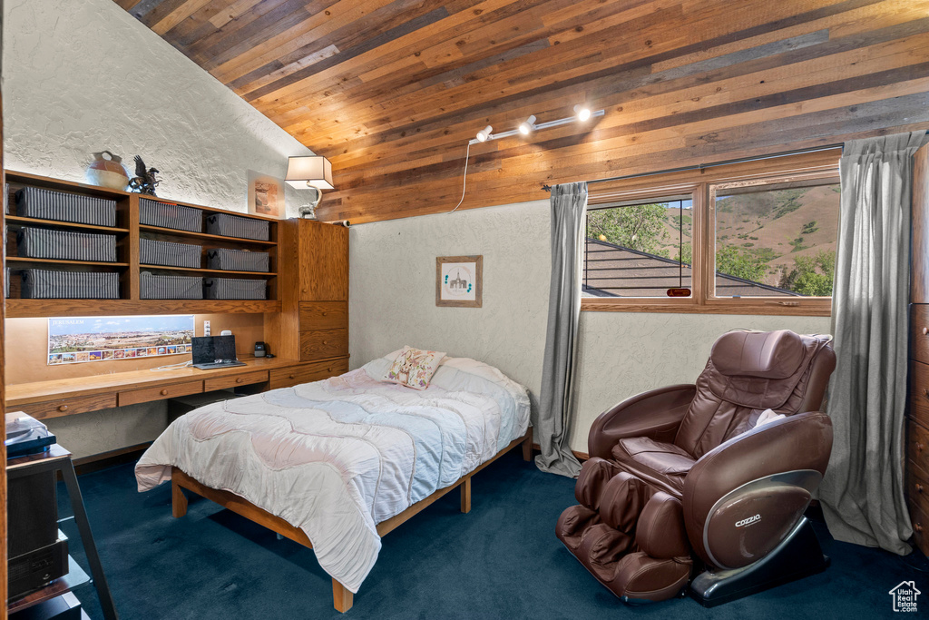 Carpeted bedroom featuring a textured wall, wood ceiling, and vaulted ceiling