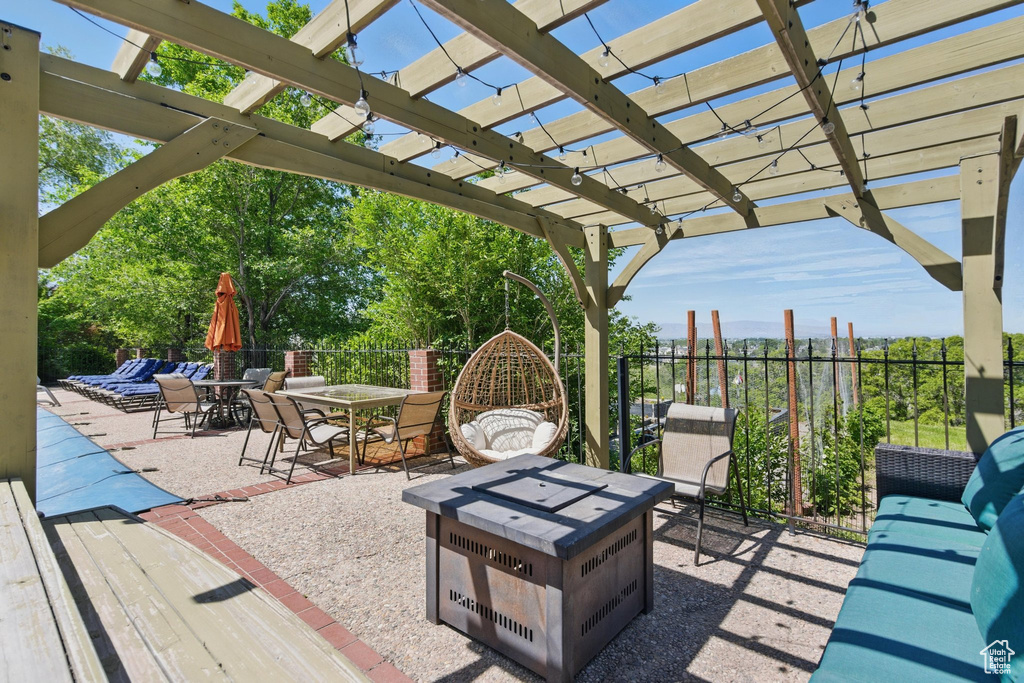 View of patio with an outdoor fire pit, a pergola, and outdoor dining space