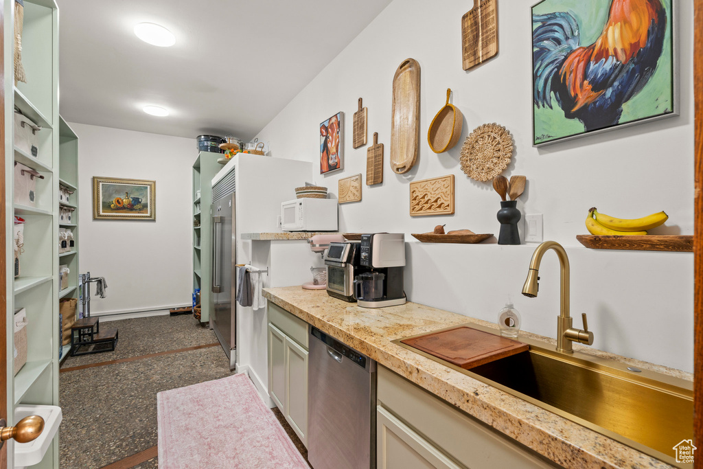 Kitchen featuring dishwasher, a sink, white microwave, and light countertops