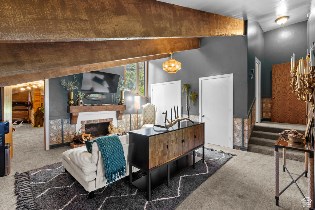 Carpeted living area with a chandelier and a fireplace with raised hearth