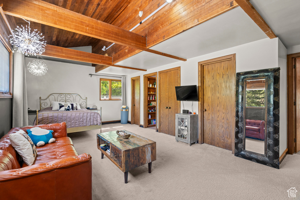 Bedroom with carpet floors, a chandelier, and wood ceiling with exposed beams