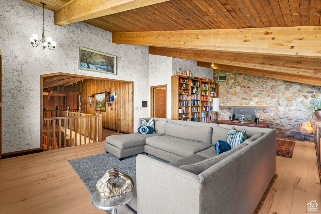 Living room featuring a chandelier, hardwood / wood-style floors, and wooden ceiling with exposed beams
