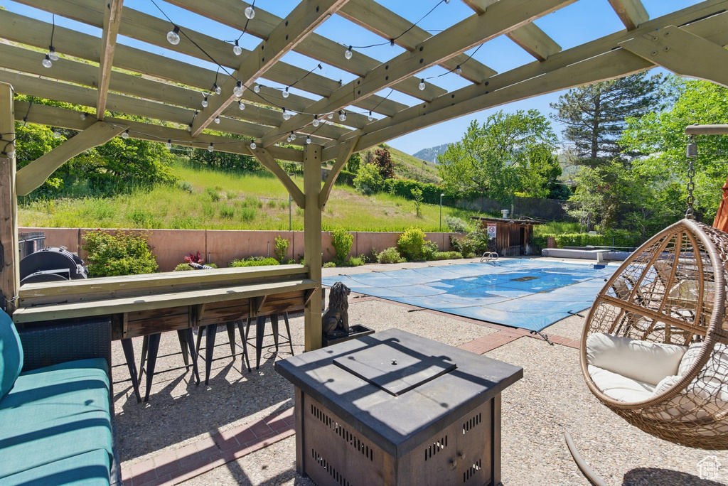 View of swimming pool with a mountain view, a pergola, a patio, and an outdoor fire pit