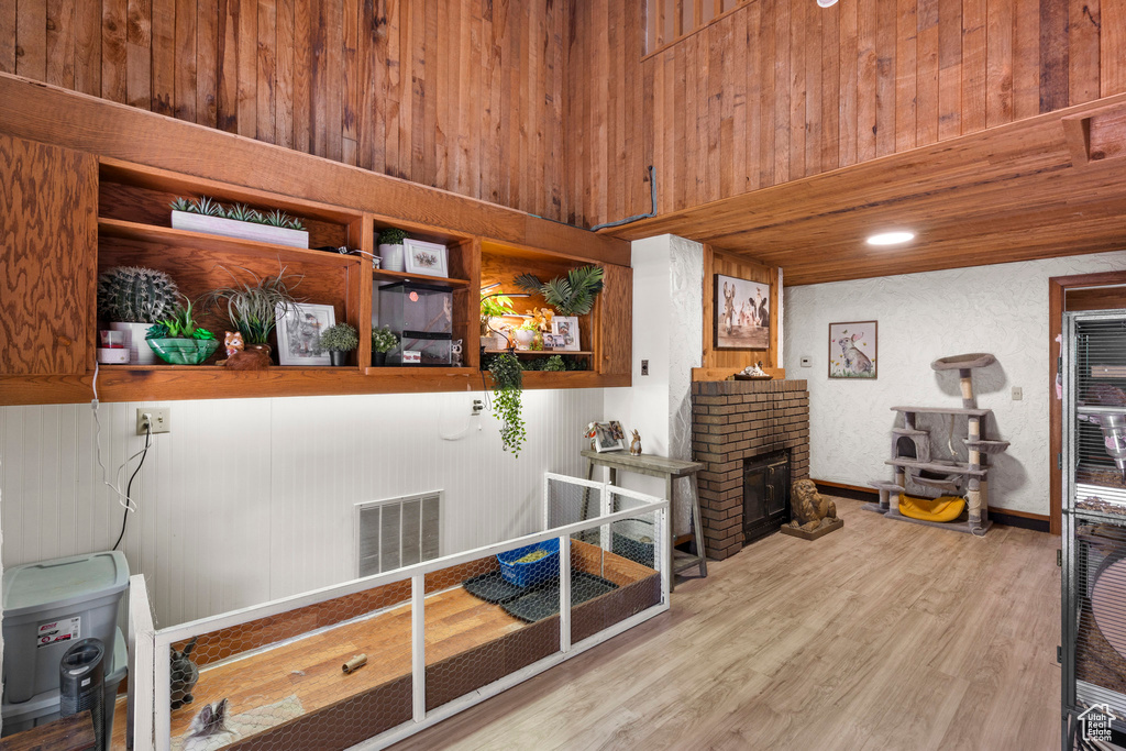 Misc room featuring wood finished floors, a fireplace, and wood walls