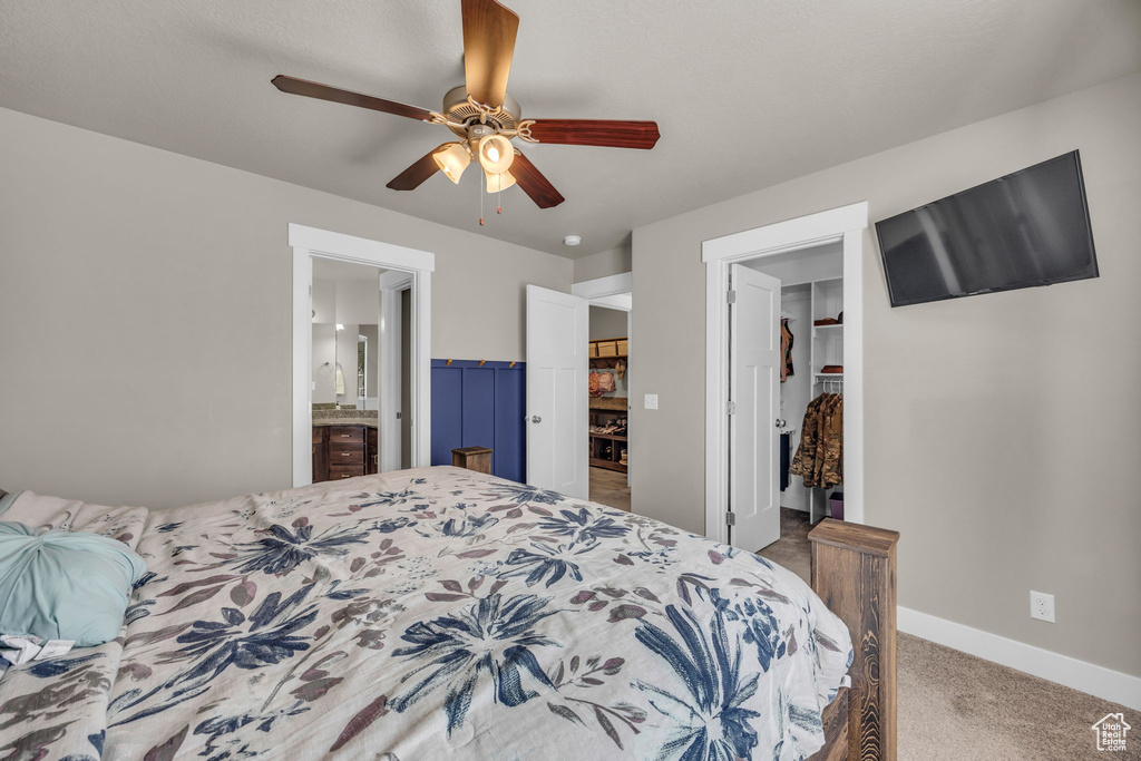 Bedroom with a walk in closet, carpet floors, a closet, baseboards, and ensuite bathroom
