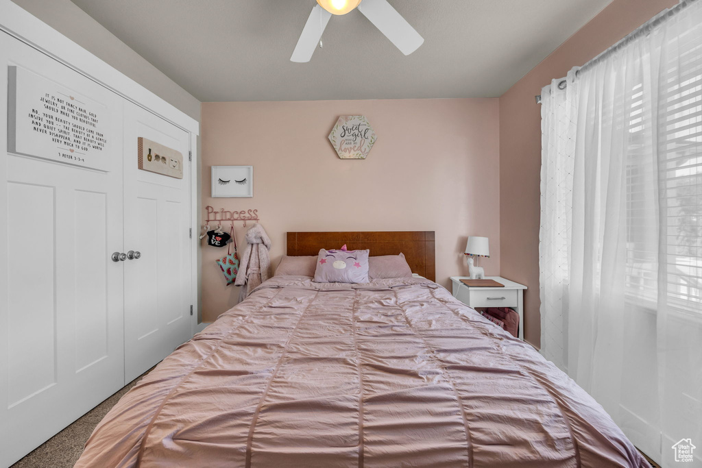 Bedroom with carpet flooring, a ceiling fan, and a closet
