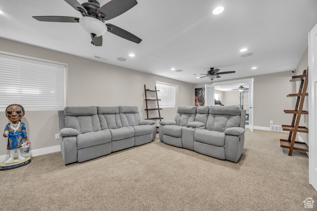 Carpeted living room featuring ceiling fan, recessed lighting, and baseboards