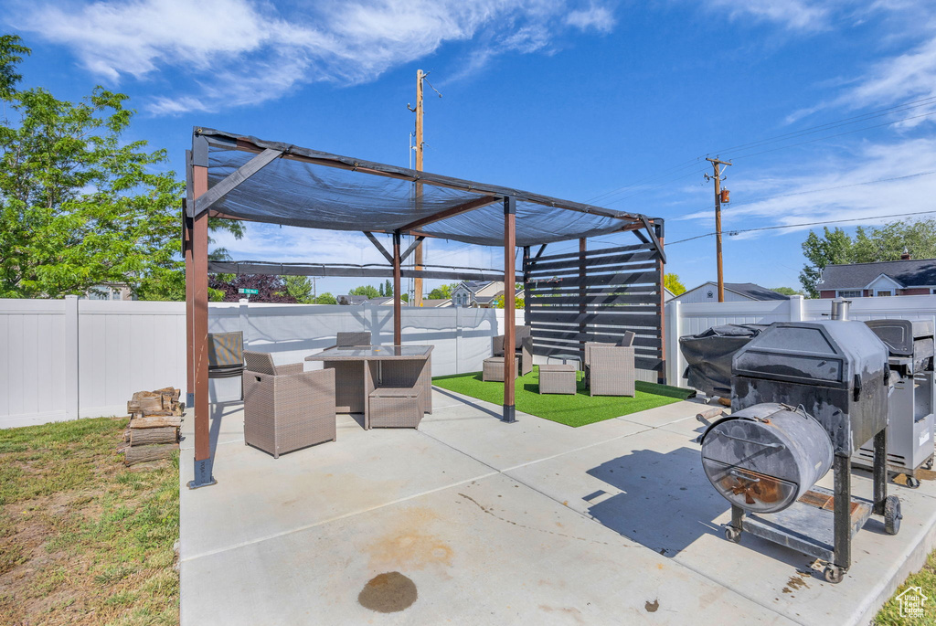 Fenced backyard featuring a fire pit and a patio