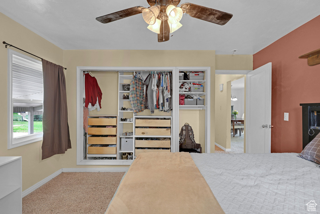 Bedroom with carpet flooring, baseboards, and a ceiling fan