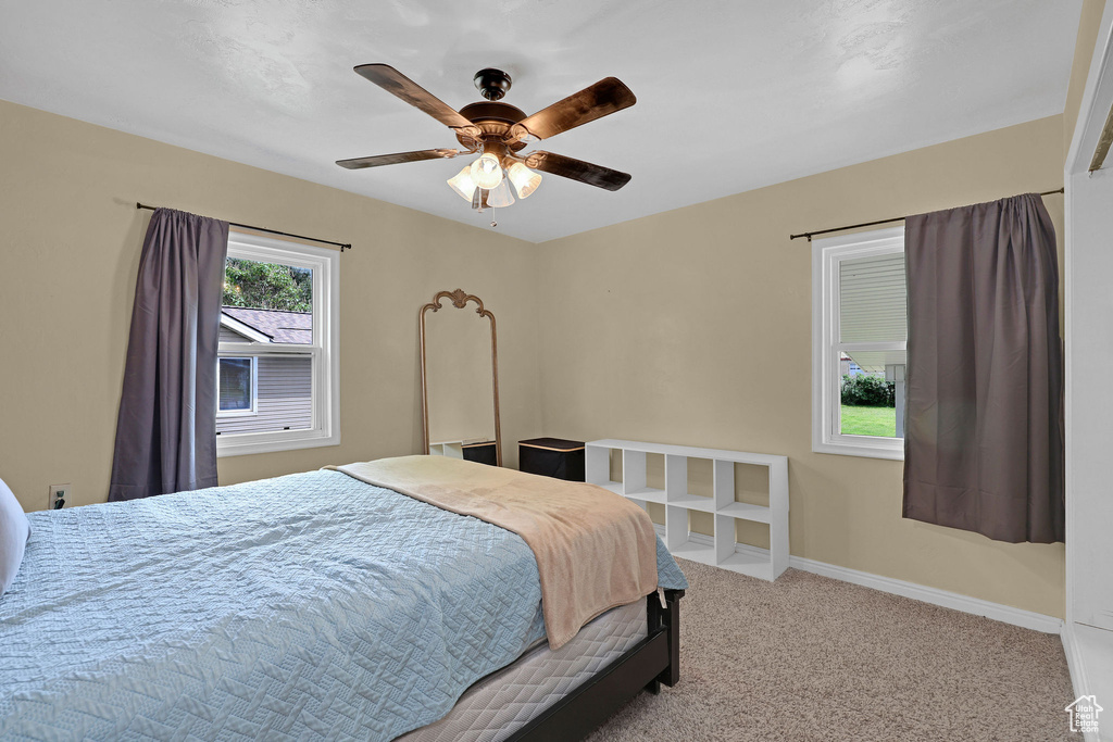 Carpeted bedroom with baseboards and a ceiling fan