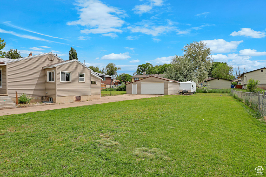 View of yard with a detached garage, an outdoor structure, and a residential view
