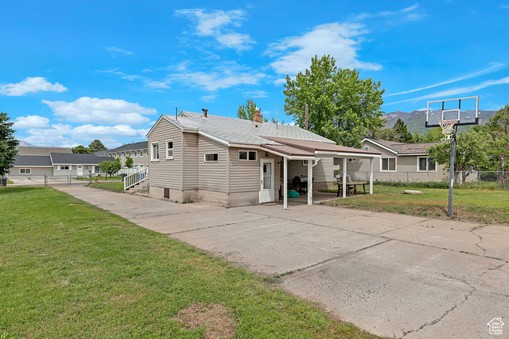 Rear view of property featuring concrete driveway and a chimney