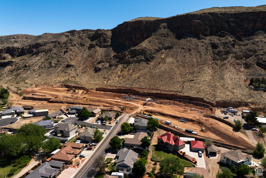 Aerial view of property and surrounding area with a mountain backdrop and nearby suburban area