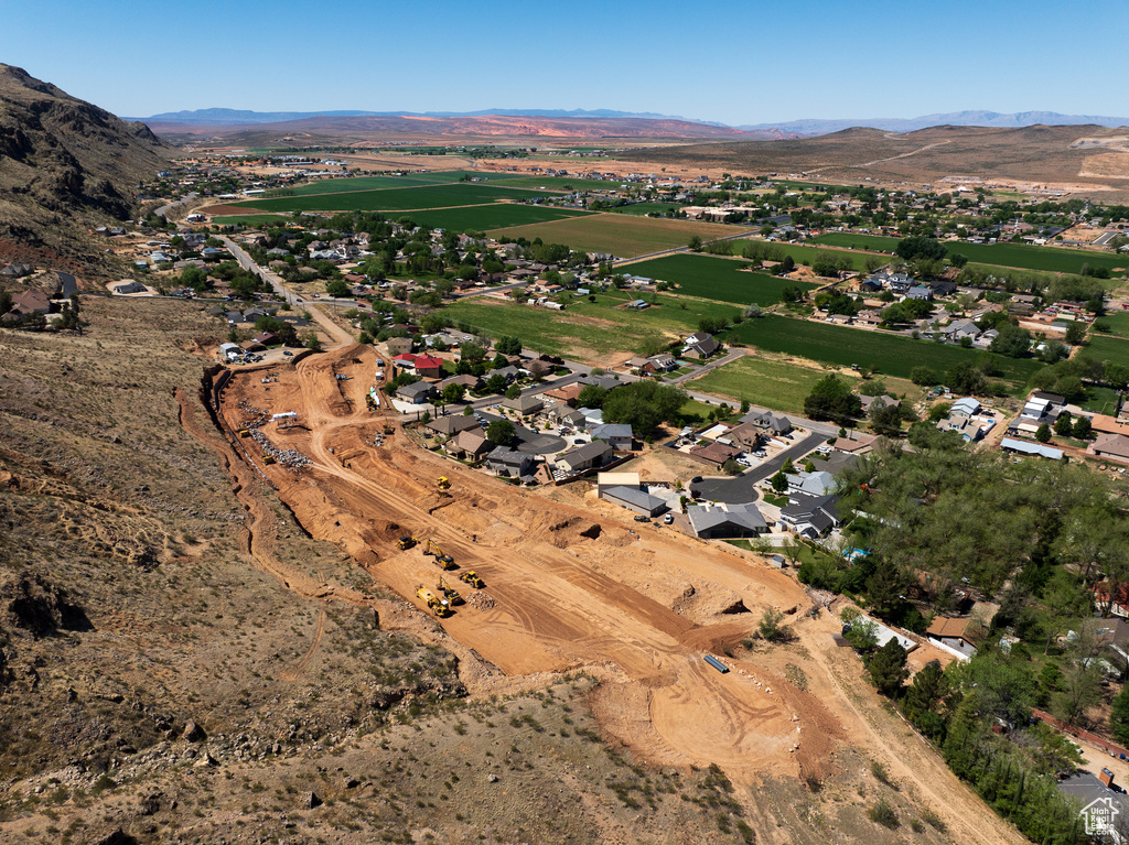Aerial view of property and surrounding area featuring a mountainous background