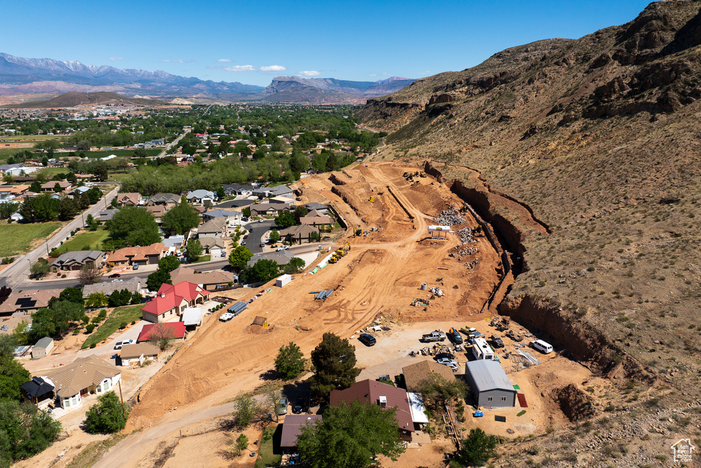 Aerial view of property and surrounding area with mountains and nearby suburban area