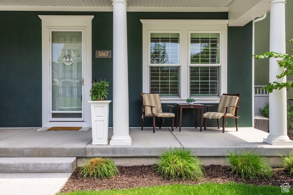 Doorway to property with a porch and stucco siding