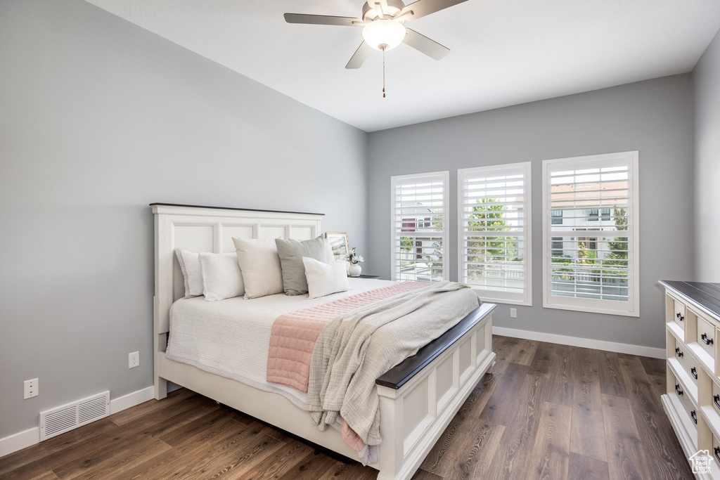 Bedroom with dark wood-type flooring, baseboards, and a ceiling fan