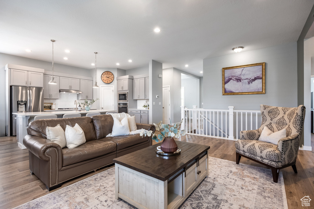 Living area with light wood finished floors and recessed lighting