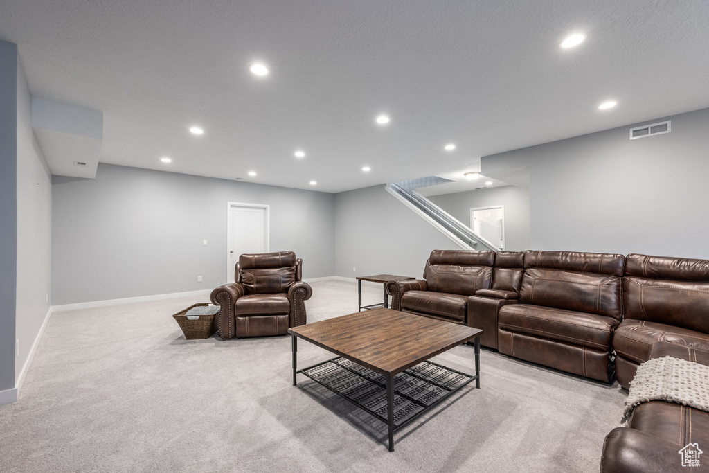 Living area with light carpet, recessed lighting, baseboards, and stairway