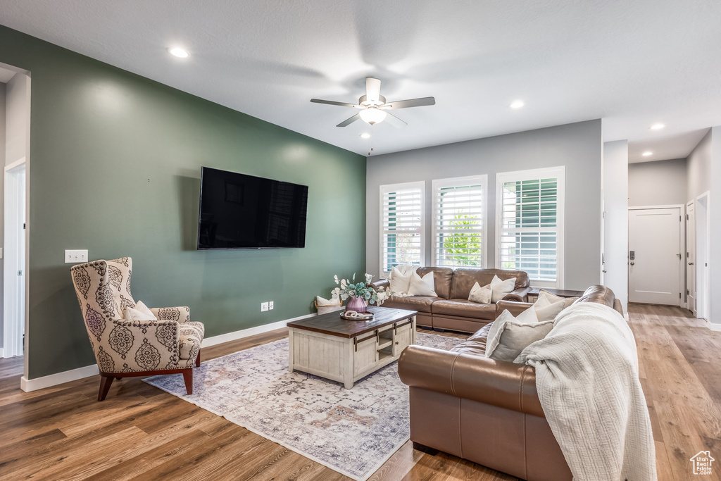 Living area with ceiling fan, light wood-style flooring, baseboards, and recessed lighting