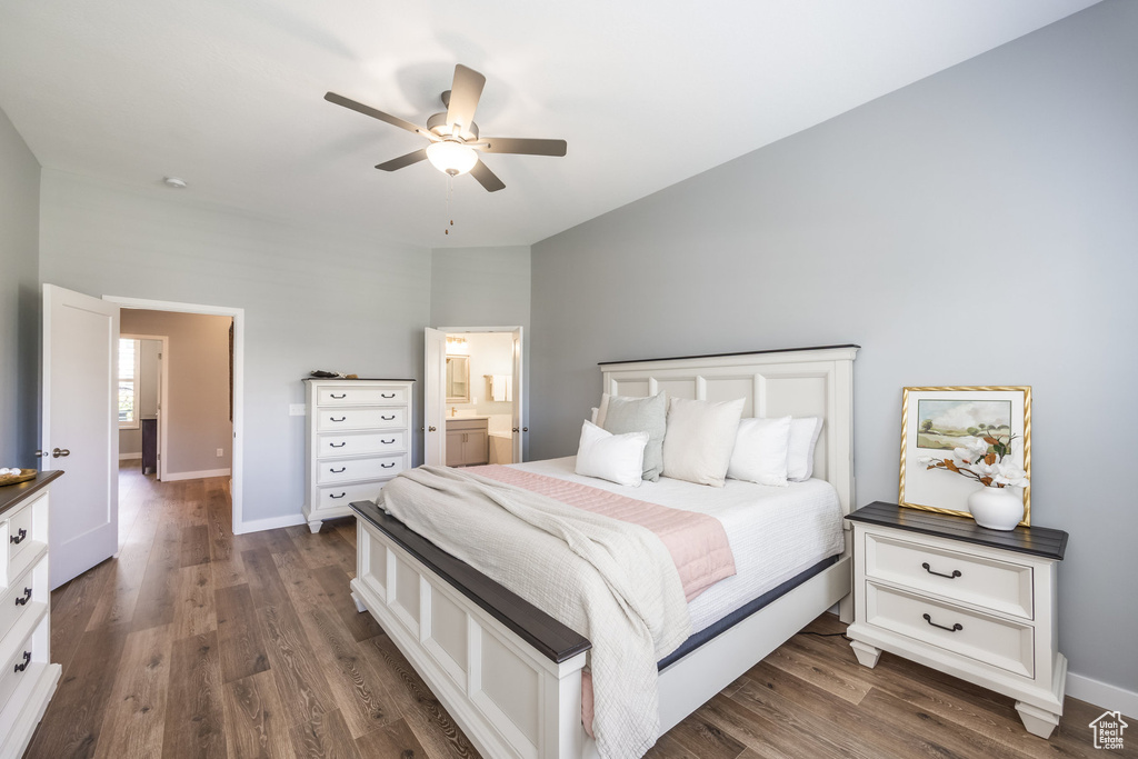 Bedroom with dark wood finished floors, baseboards, connected bathroom, and ceiling fan