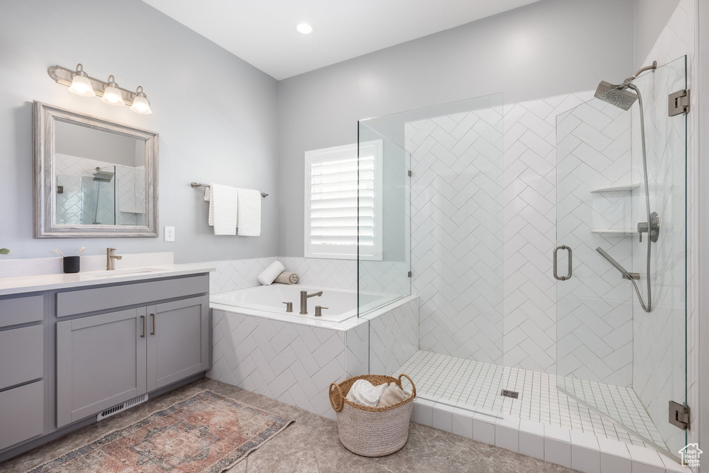 Full bathroom featuring vanity, a garden tub, a stall shower, and tile patterned floors