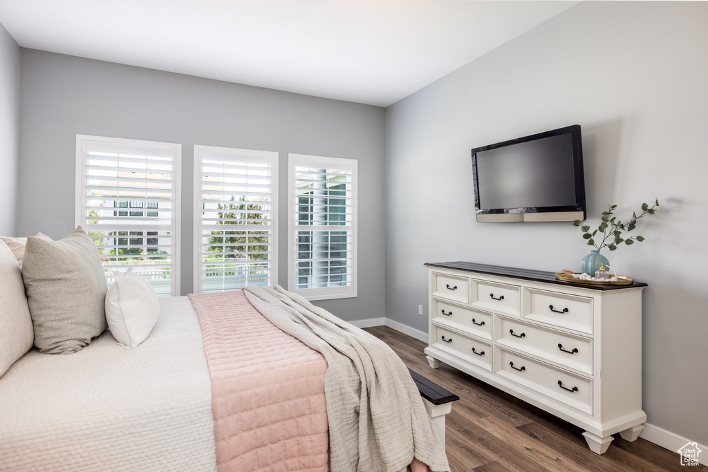 Bedroom featuring dark wood-style floors and baseboards