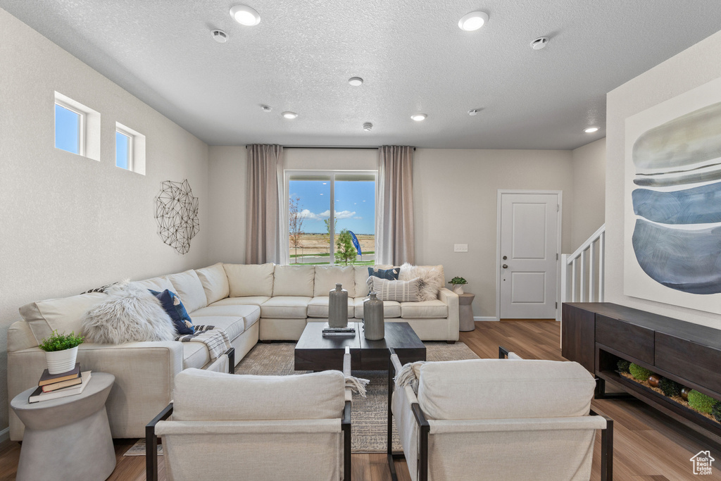 Living area featuring plenty of natural light, wood finished floors, recessed lighting, and a textured ceiling