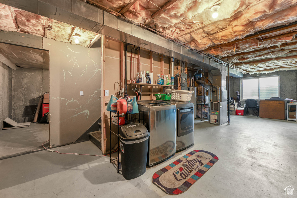 Basement featuring washing machine and dryer and heating unit