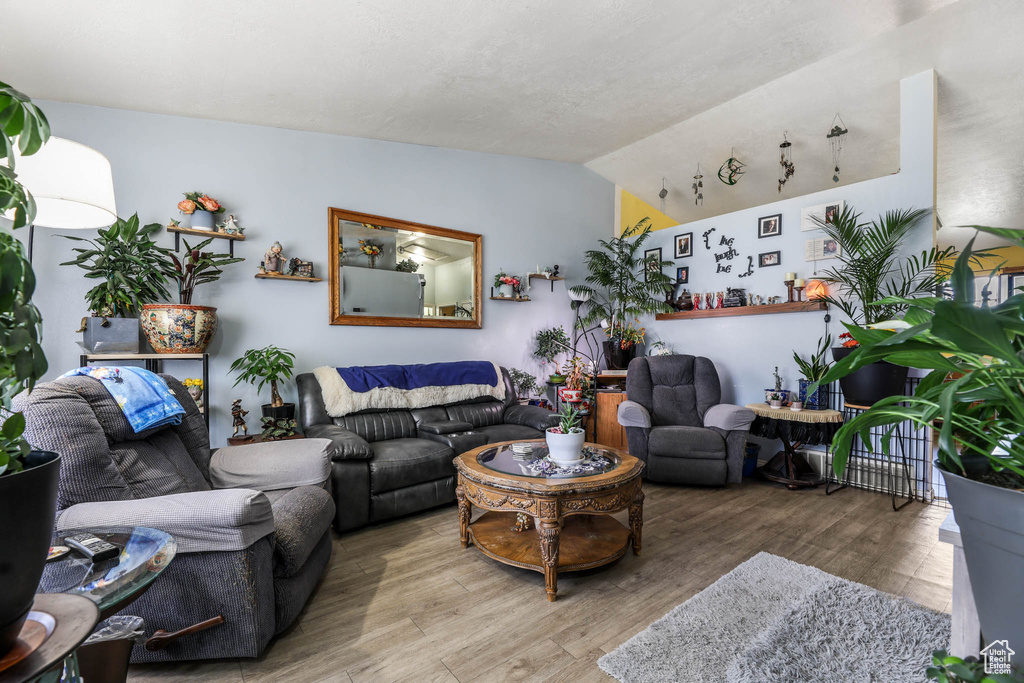 Living room with wood finished floors and vaulted ceiling