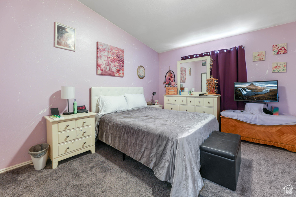 Bedroom featuring carpet and vaulted ceiling