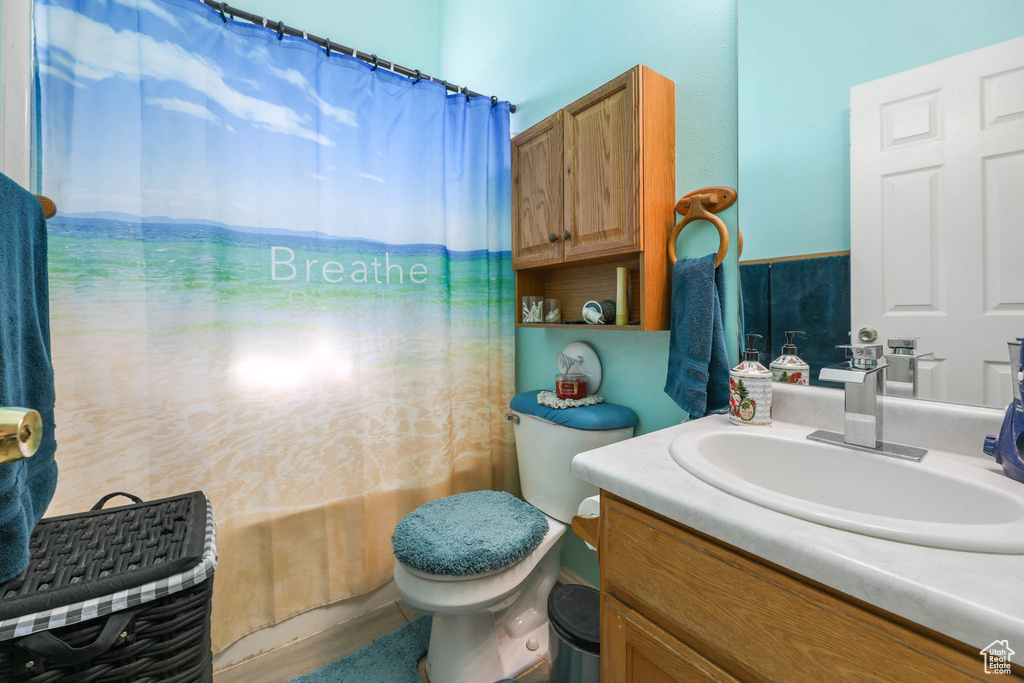 Bathroom featuring vanity, toilet, and shower / bath combination with curtain