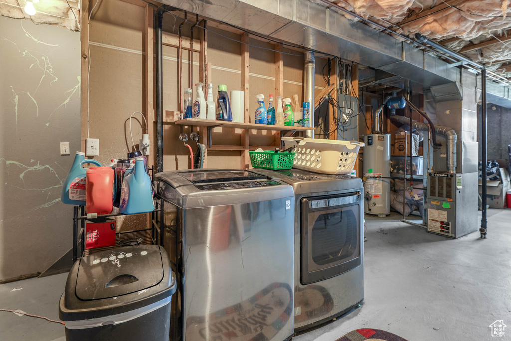 Washroom featuring water heater, heating unit, and washing machine and clothes dryer