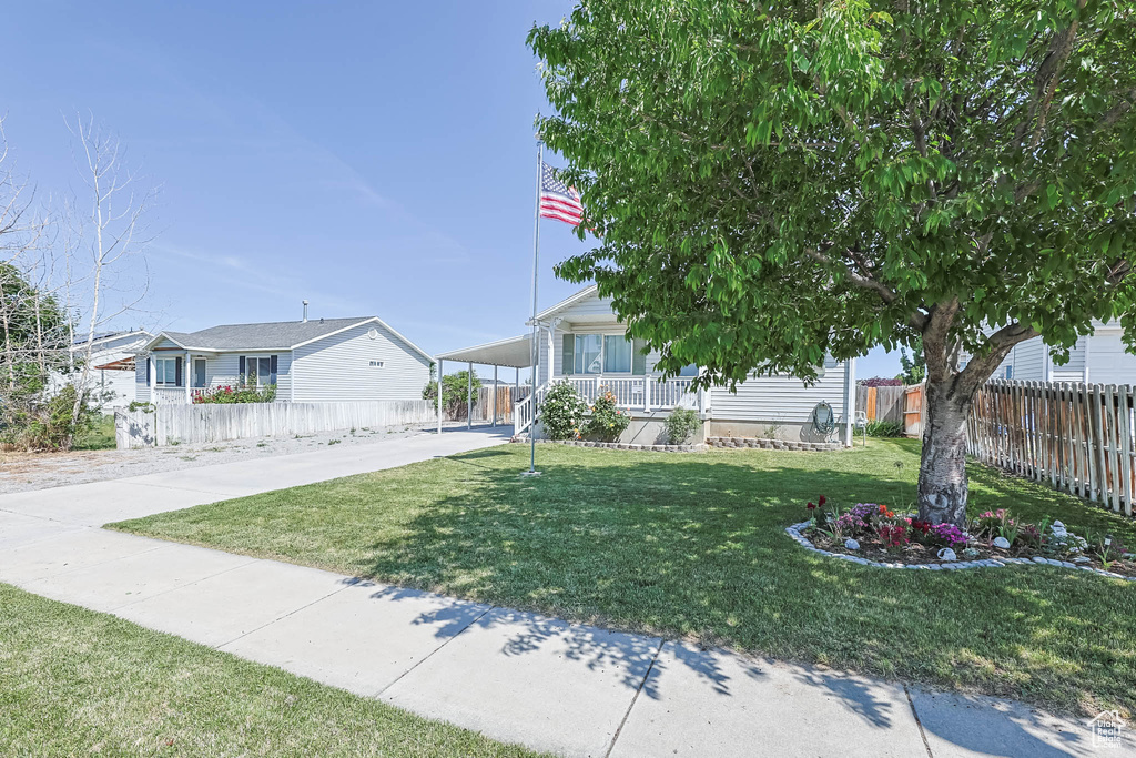 View of front of house with covered porch, a carport, and concrete driveway