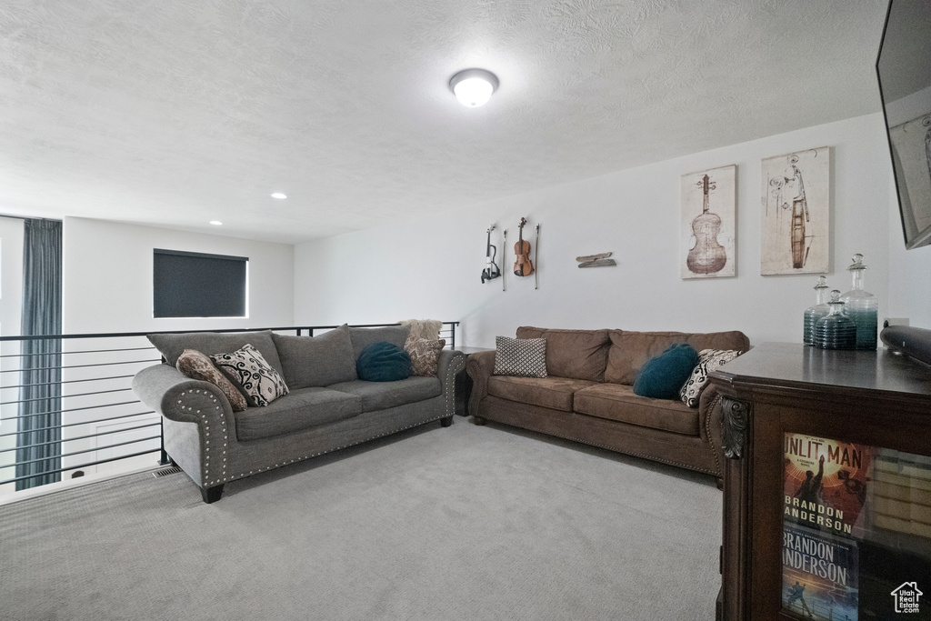 Carpeted living room with a textured ceiling and recessed lighting